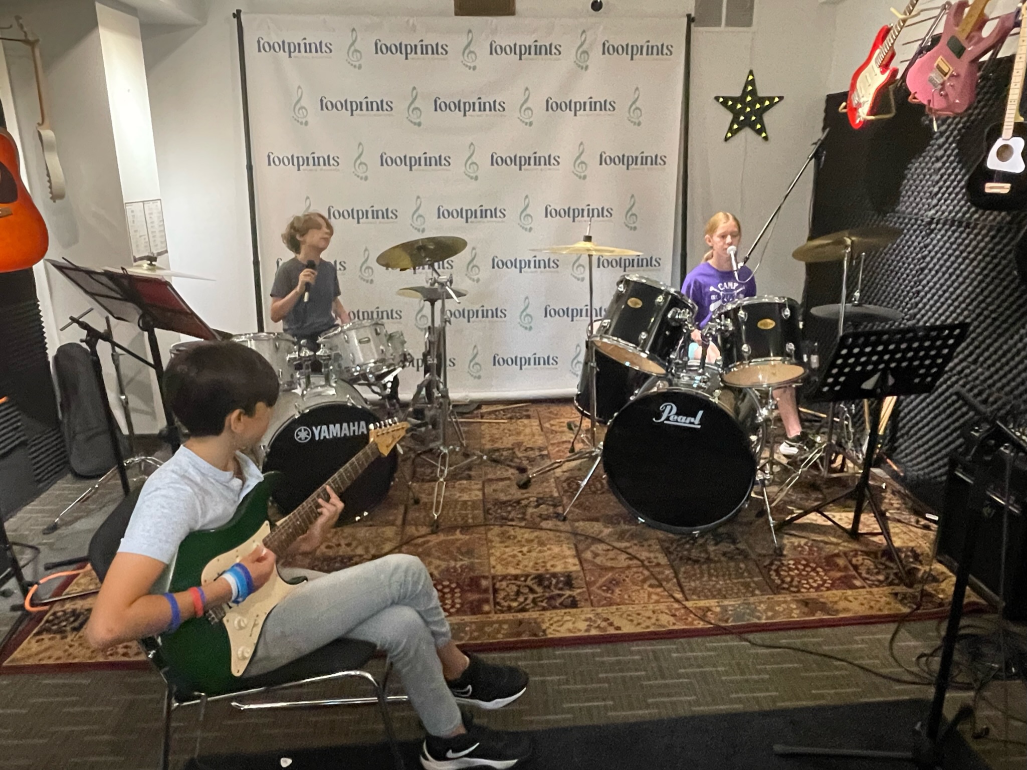 Camper playing guitar during Summer Rock Camp at Footprints Music